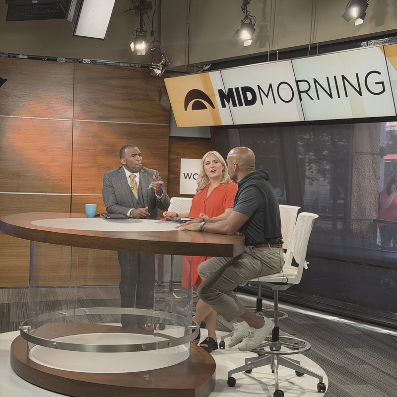 Jarrett on a morning television set talking with two hosts.